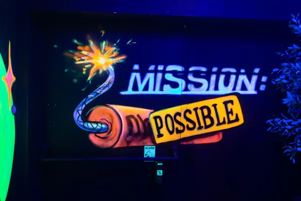 Leuchtschrift Mission: Possible mit gemalter Dynamitstange