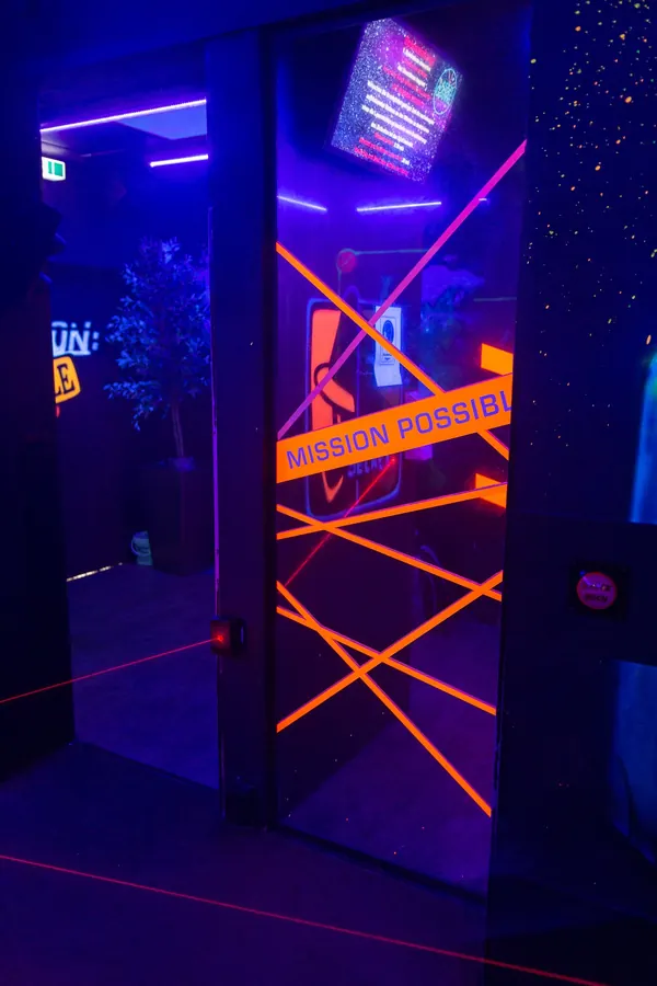 Durchgang mit orangen Laserlinien und Absperrband Mission Possible, Hochformat