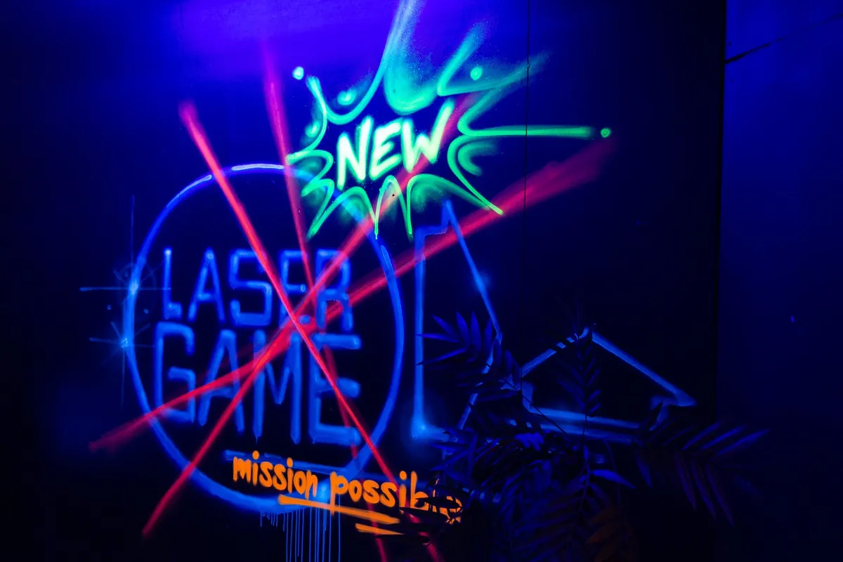 Leuchtendes Neonschild Laser Game mission possible an einer dunklen Wand
